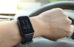 Man watching time by his smart watch on car.smart healt band on wrist.black wrist band watch.