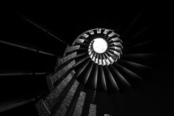 Spiral staircase with steps, upward view of a skylight, in monochrome