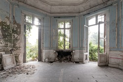 Abandoned castle, room with fireplace and large broken windows