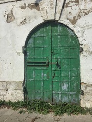 Front of the old  building, green historic wooden door (gate)
