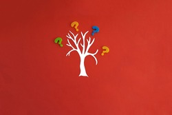 Tree, question marks on a red background. The concept of issues in the conduct of a joint business project, the solution of the tasks set by the task.