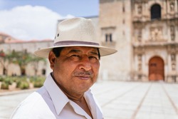 Mexican grandfather smiling at camera. adult latino with hat on a sunny day