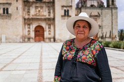 Mexican women adult smiling at camera. Happy smiling Latin American grandmother standing in office and looking at camera