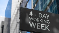 4 - Day working week on a black city-center sign in front of a modern office building	