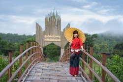 An Asian woman dressed in traditional Northern Thailand culture on the longest bamboo bridge (Su Tong Pae bridge) at Suan Tham Phu Sama temple place of worship in Mae Hong Son, Thailand.