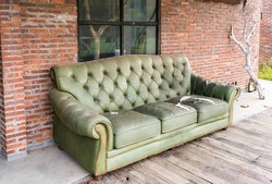 old abandoned house front with green sofa