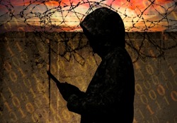 A hacker stands against the wall of a prison with barbed wire. Cyber security. Prison