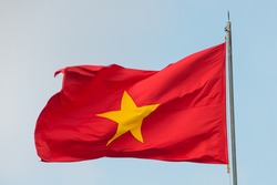 Flying Vietnamese flag isolated on a blue sky background in the bright sunny day