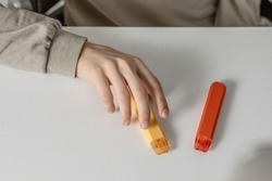 electronic cigarettes in the hands of a teenager sitting at a white table, danger to health and harm from smoking cigarettes and vapes