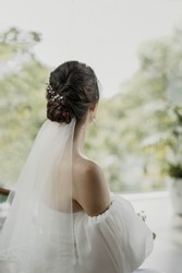 bride in a veil. bride's back on a light background. bride in a white wedding dress. bride's veil