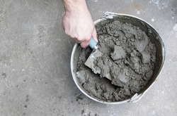 Mixing of concrete mortar.The builder prepares the cement mortar using a construction trowel.Plaster mortar in a bucket.