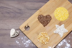 Various types of cereals on the table in the shape of a heart, a circle and a star, top view, free space for text