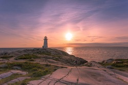 A dramatic sunset at Peggy's Cove Lighthouse Atlantic Coast Nova Scotia Canada. The most visited tourist location in the Atlantic Canada and famous Lighthouse captured with vibrant colors. 