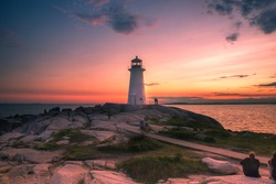 A dramatic sunset at Peggy's Cove Lighthouse Atlantic Coast Nova Scotia Canada. The most visited tourist location in the Atlantic Canada and famous Lighthouse captured with vibrant colors