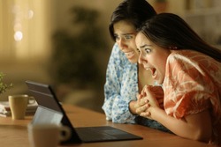 Terrified women watching media on laptop in the night at home