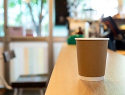 One Coffee cup paper placed on a wooden table, in a cafe coffee shop drinks are available. Hot inside for takeaway ready to drink, refreshing. aroma awake fresh to work placed 