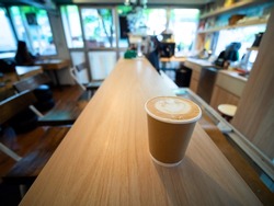 One brown Coffee cup paper placed on a wooden table, in a cafe coffee shop drinks are available. Hot inside for takeaway ready to drink, refreshing. aroma awake fresh to work placed 
