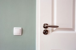 Modern white door with chrome door handle and light switch, new clean design retro