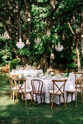 
magical wedding ceremony outside in the garden with hanging light and flowers, chairs, outdoor ceremony in the open air