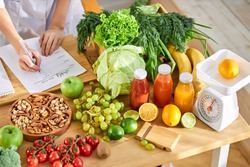 Young Dietitian writing diet plan, view from above on table with different healthy products