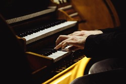 Close up of musician's hands playing the organ.