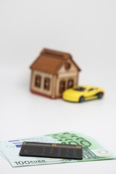 The calculator lies on European banknotes on the background of a yellow car, an accurate financial calculation
