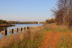 Concrete foundations of the old pier against the background of the new bridge over the Volga, autumn background
