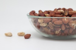 Peeled and salted peanuts in a bowl. Isolated on a white background