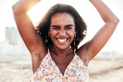 Portrait of a young black woman having fun at beach party - Happy female enjoying sunset by the sea - Beauty, positive and happy lifestyle concept