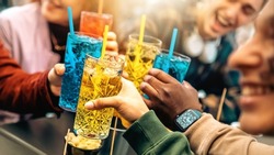 Group of friends cheering drinks glasses together - Young people enjoying happy hour at cocktail open bar - Beverage lifestyle concept
