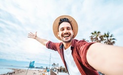 Handsome man taking selfie in Barcelona city, Spain - Happy tourist having fun walking outside on summer vacation - Travel, holidays and European landmarks concept