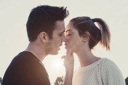 Loving couple kissing outdoor at sunset - Concept about people, love and lifestyle