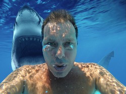 (photomanipulation)European man diving with shark. Scary selfie with shark under water. Shark behind his back with open jaw. most downloaded.
