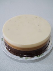 caramel - combination pudding with white, brown and dark colour of the layer. different flavour every layer, milk, caramel and chocolate. gritty, grainy and shiny textured. white isolated