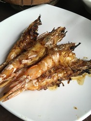 sate udang or sweet grill shrimp on white plate. close up. gritty and grainy textured. White isolated and selective focus