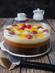 caramel combination pudding with varian fruits as topping. different flavour every layer, milk, caramel and chocolate. gritty, grainy and shiny textured with vla as blurry background