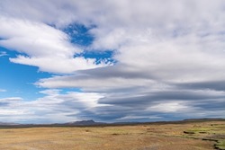 Panoramic view of the barren Icelandic Highlands with volcanos and mountains in the northern part of Iceland with a beautiful blue sky with large white fluffy clouds
