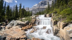 Big cascade waterfall in alpine environment with mountains in background,Banff National Park,Canada