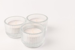 White wax candles in glass holder on white background. Tea light.