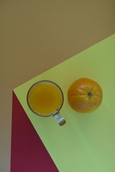 And orange, juice, a  glass on a threedimensional table.