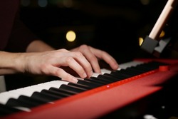 women hands playing grand piano at night 