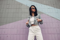 Beautiful Brunette Girl in Sunglasses White Pants and Jeans Jacket
