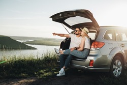 Man and Woman Relaxing Inside Car Trunk Enjoying Weekend Road Trip, Travel and Adventure Concept