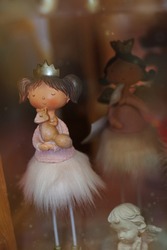 Cute princess toy in a delicate dress. Ceramic doll with a squirrel in hands. Magical girl in pink fluffy skirt and gold crown. Toy shop. Store of interesting toys. A wonderful gift for a little girl