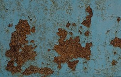 Cracked blue paint on an old metallic surface with corrosive rust. Rusty metal background and texture concept