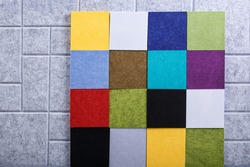 Set of colored squares made of acoustic polyester on a gray background