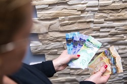 Woman is holding Canadian dollars in her hands. Canadian money in different nominals