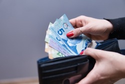 woman has Canadian dollars in her hands. 