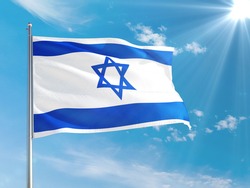 Israel national flag waving in the wind against deep blue sky. High quality fabric. International relations concept.