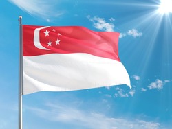 Singapore national flag waving in the wind against deep blue sky. High quality fabric. International relations concept.